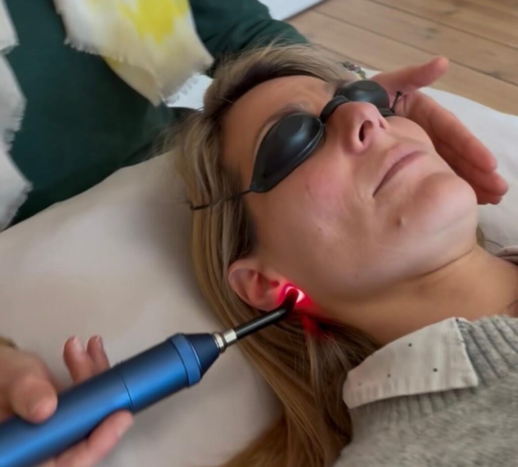 Séance de réflexologie au laser doux sur un point réflexe du visage
